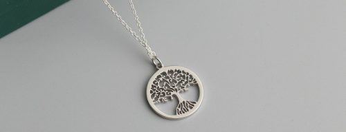 a silver tree of life pendant on a chain
